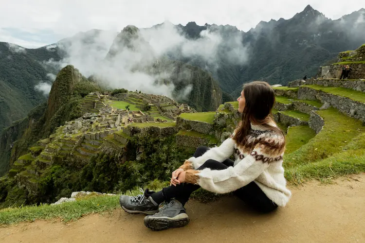 Una viajera en machu picchu que usa aplicaciones para viajeros