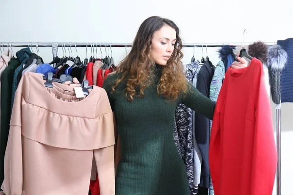 mujer indecisa al comprar ropa