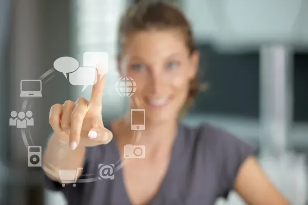 mujer sonriente presionando una pantalla táctil