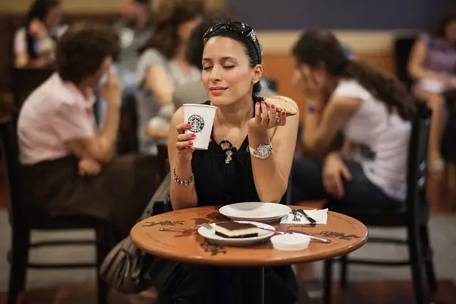 mujer disfrutando del aroma a cafe en starbucks