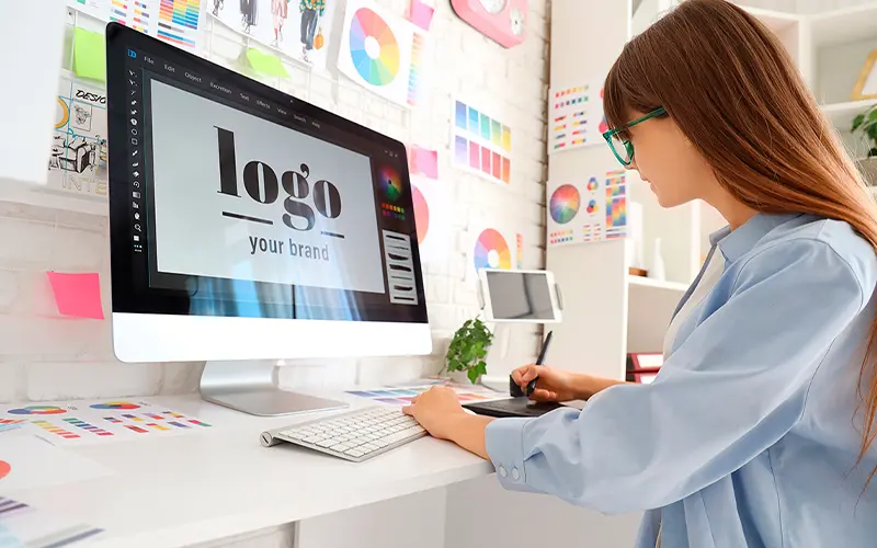 una chica trabajando en el diseño gráfico de un logo