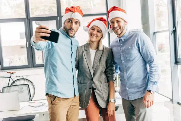 Grupo de compañeros de trabajo grabando contenido para navidad debido a que es una tendencia