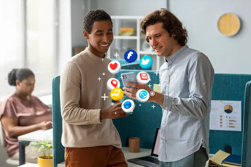 dos jovenes con un movil y todas las aplicaciones de redes sociales