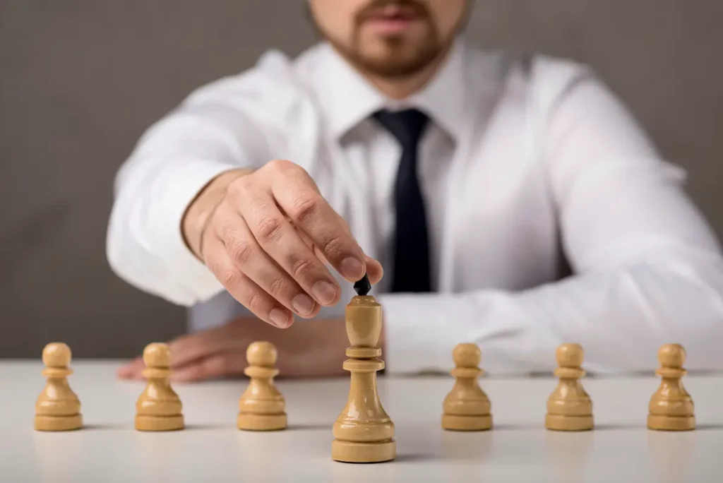 Ejecutivo moviendo pieza de ajedrez como símbolo de estrategia competitiva empresarial