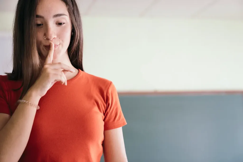 Persona en silencio con gesto reflexivo, representando cómo la falta de respuesta también comunica un mensaje.