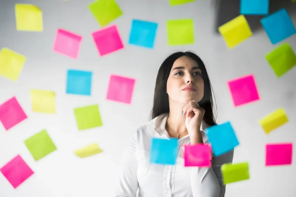 Mujer evaluando opciones con notas adhesivas